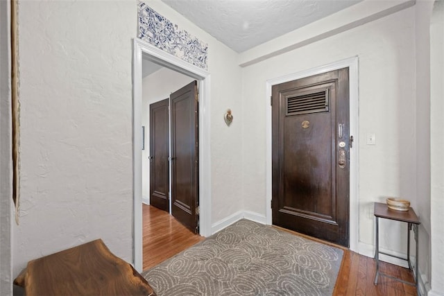 372 S Highland Ave Unit 606, Shadyside, PA 15206 - entryway with wood finished floors, a textured wall, and baseboards