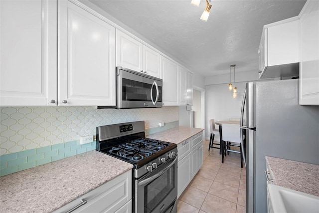 372 S Highland Ave Unit 606, Shadyside, PA 15206 - kitchen with stainless steel appliances, backsplash, white cabinetry, light tile patterned flooring, and hanging light fixtures