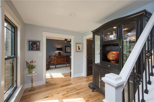hall with light wood-type flooring and baseboards