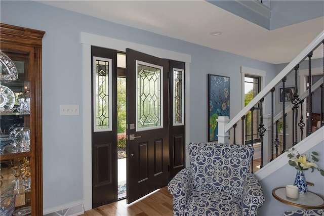 foyer with wood finished floors and stairway