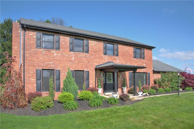 view of front of property with a front yard and brick siding