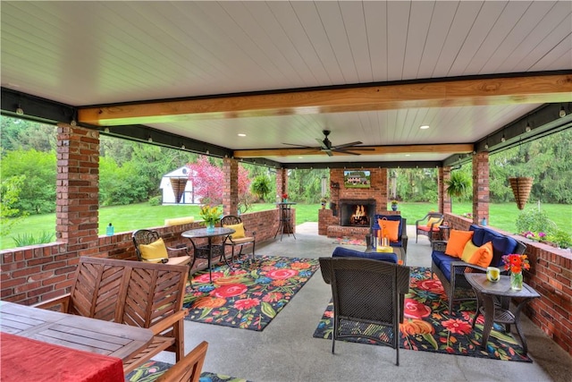 view of patio / terrace featuring an outdoor living space with a fireplace and a ceiling fan
