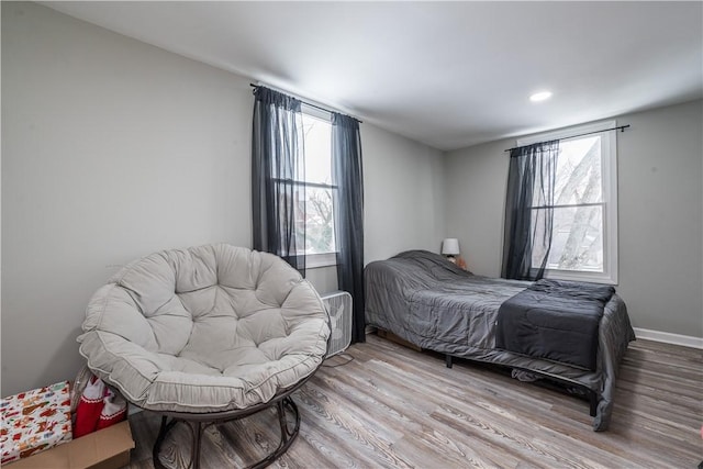 bedroom featuring wood finished floors, multiple windows, recessed lighting, and baseboards