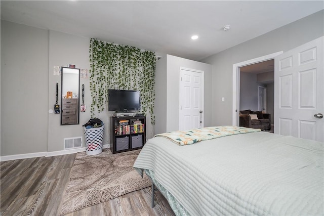 bedroom featuring wood finished floors, baseboards, and recessed lighting