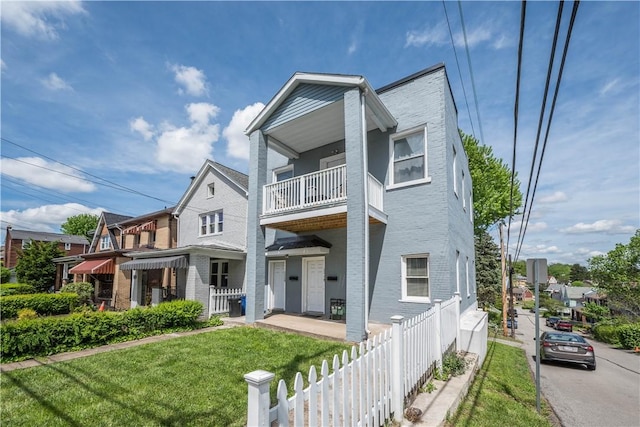 multi unit property with a balcony and brick siding