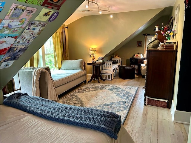 bedroom with hardwood / wood-style flooring and lofted ceiling