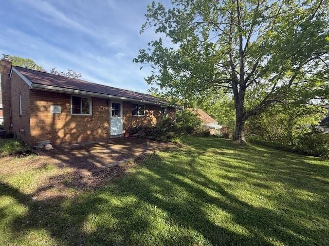 130 Anthon Dr, Penn Hills, PA 15235 - rear view of property featuring a chimney, a yard, and brick siding