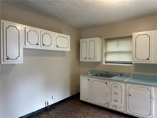 6511 Clifford St, Lincoln-Larimer, PA 15206 - kitchen with a sink, white cabinetry, light countertops, and baseboards