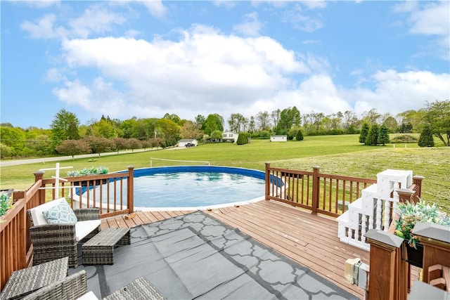 view of pool with a deck, a lawn, and view of scattered trees