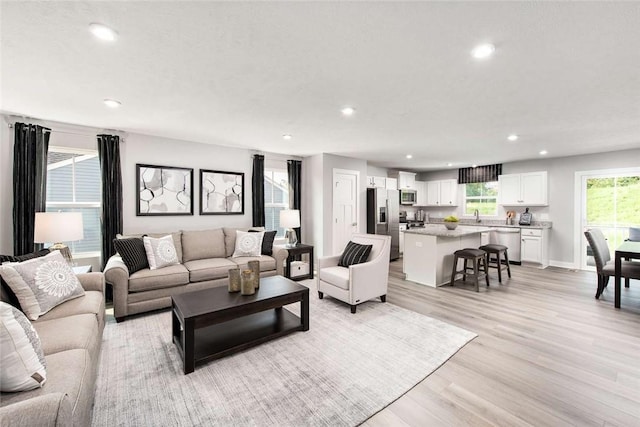 living room with recessed lighting, light wood finished floors, and baseboards