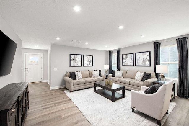 living room with recessed lighting, light wood finished floors, and baseboards