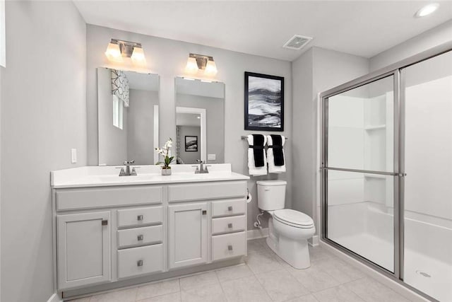 full bathroom with toilet, baseboards, a stall shower, double vanity, and tile patterned flooring