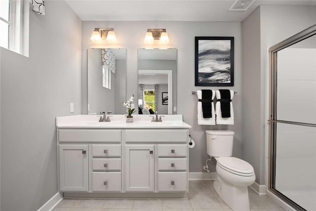 full bath featuring toilet, baseboards, double vanity, and tile patterned floors