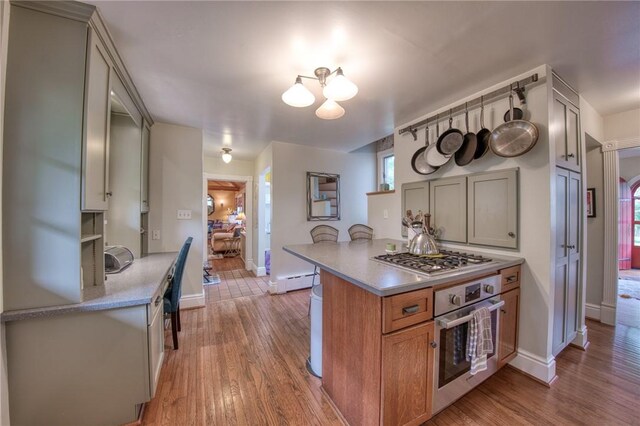 1010 Glenshaw Ave, Shaler, PA 15116 - kitchen with stainless steel appliances, a baseboard radiator, light countertops, a chandelier, and light wood-style floors