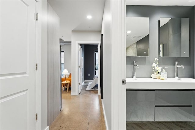 bathroom with baseboards, speckle patterned floor, and vanity