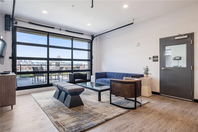 living area with wood finished floors, recessed lighting, and expansive windows