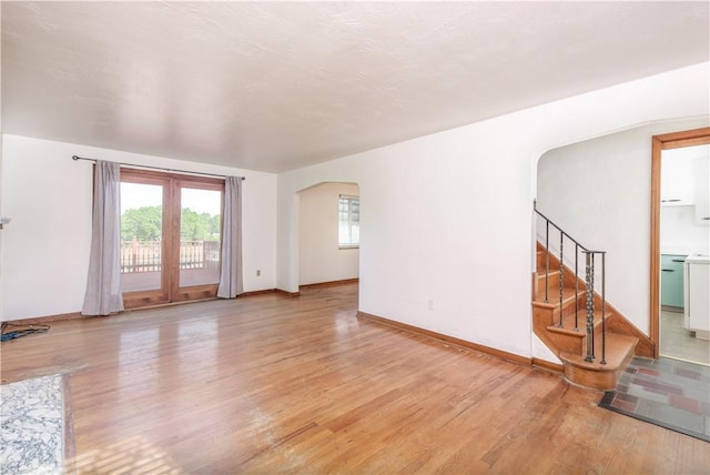 5251 Meadowgreen Dr, Whitehall, PA 15236 - unfurnished living room featuring arched walkways, light wood finished floors, plenty of natural light, and baseboards
