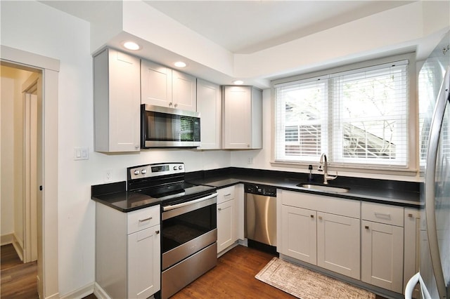 18 W Manilla Ave, Green Tree, PA 15220 - kitchen with appliances with stainless steel finishes, a sink, dark countertops, dark wood-style flooring, and recessed lighting