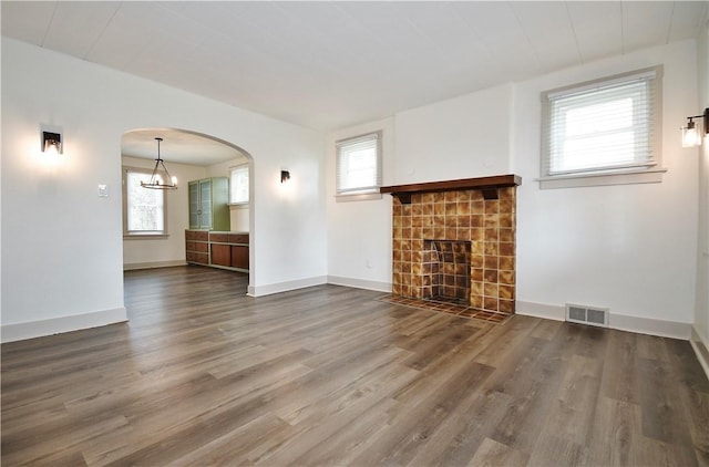 18 W Manilla Ave, Green Tree, PA 15220 - unfurnished living room featuring a tile fireplace, wood finished floors, healthy amount of natural light, and arched walkways