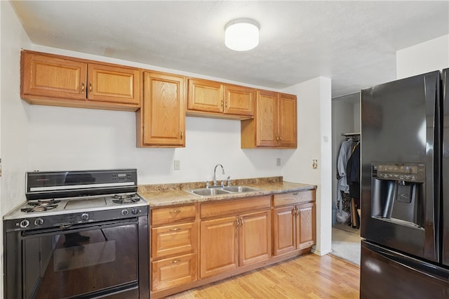 945 Key W Dr, Plum Boro, PA 15239 - kitchen with black appliances, a sink, light wood finished floors, and brown cabinets