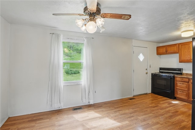 945 Key W Dr, Plum Boro, PA 15239 - kitchen with black gas stove, ceiling fan, brown cabinets, light wood-style flooring, and baseboards