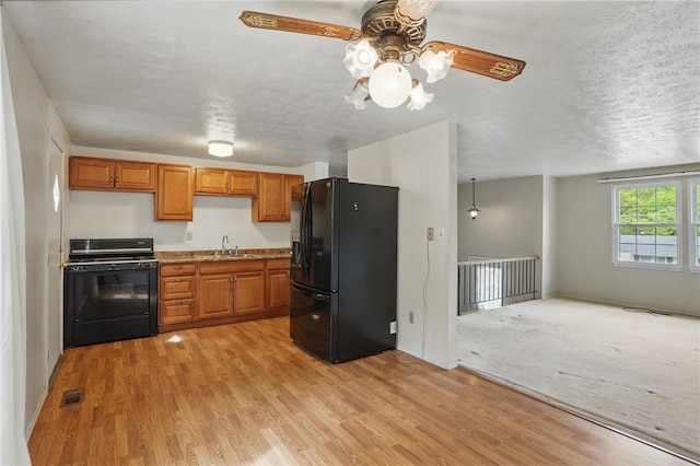 945 Key W Dr, Plum Boro, PA 15239 - kitchen with black appliances, a sink, light wood-style floors, a ceiling fan, and brown cabinetry