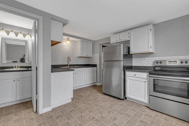 kitchen featuring appliances with stainless steel finishes, a sink, dark countertops, and backsplash