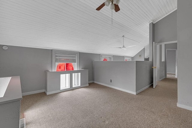 carpeted spare room with a ceiling fan, vaulted ceiling, wooden ceiling, and baseboards