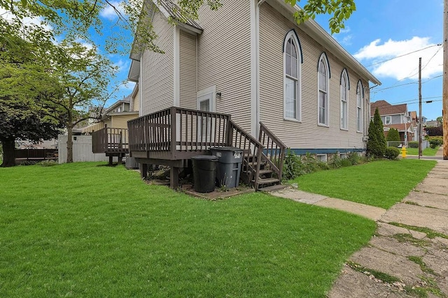 back of house featuring a lawn and a deck