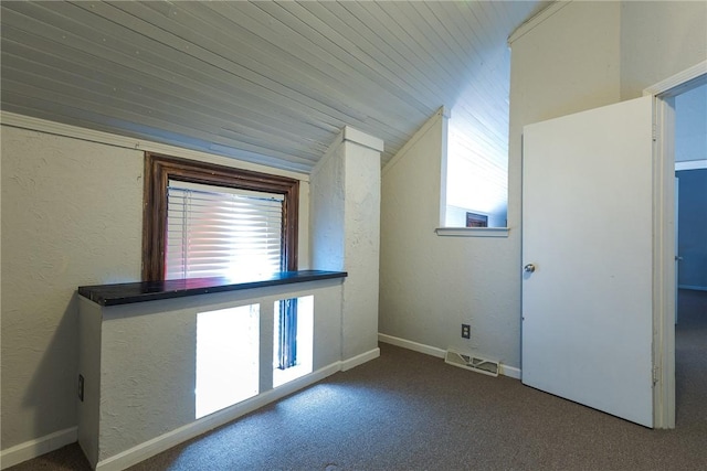 additional living space featuring plenty of natural light, carpet flooring, and vaulted ceiling