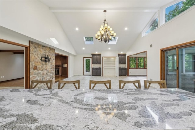 dining space with high vaulted ceiling, beam ceiling, and a chandelier