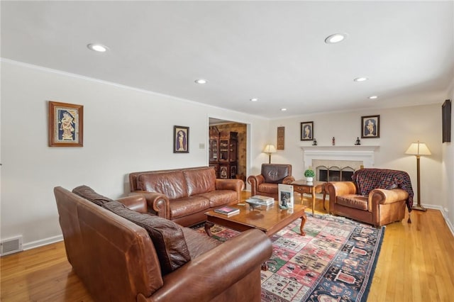 living room with recessed lighting, light wood-style flooring, a fireplace, and baseboards
