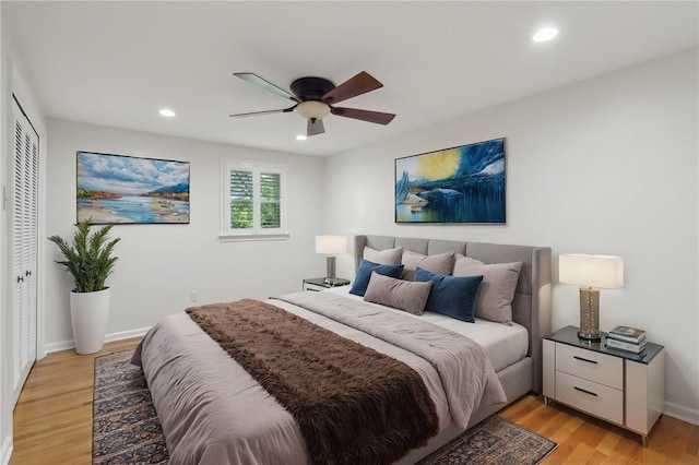 bedroom with recessed lighting, a closet, light wood-style flooring, a ceiling fan, and baseboards