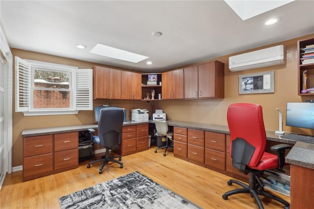 office featuring an AC wall unit, a skylight, light wood-style floors, and recessed lighting