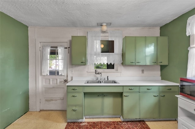 1108 Wills Ave, Lower Burrell, PA 15068 - kitchen featuring green cabinets, a sink, light countertops, light flooring, and a textured ceiling
