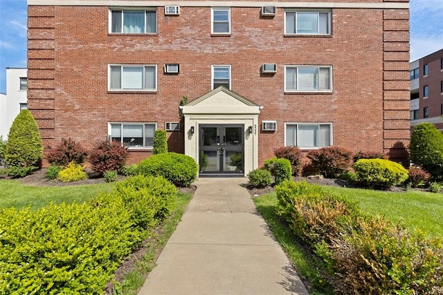 view of apartment building / complex with an AC wall unit