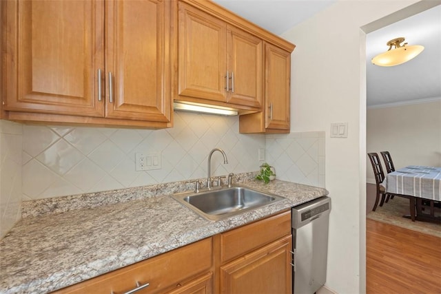 kitchen featuring dishwasher, a sink, light wood-type flooring, tasteful backsplash, and ornamental molding