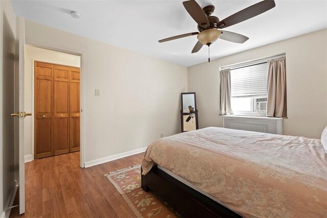 bedroom with wood finished floors, baseboards, ceiling fan, and radiator heating unit