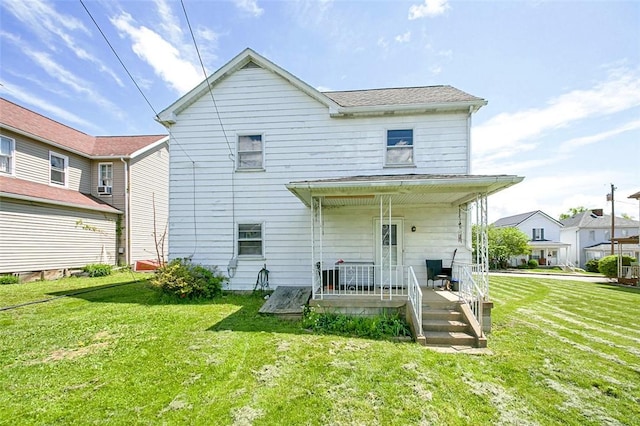 rear view of house with covered porch and a lawn