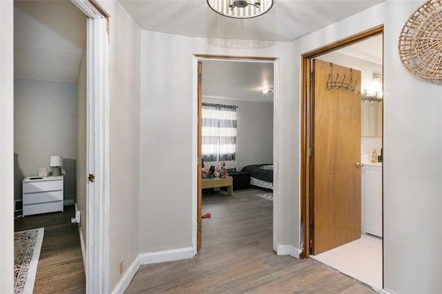 corridor featuring wood finished floors and baseboards