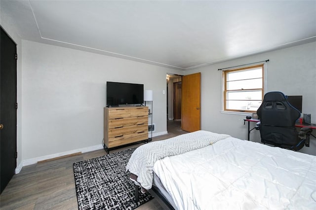 bedroom with wood finished floors and baseboards