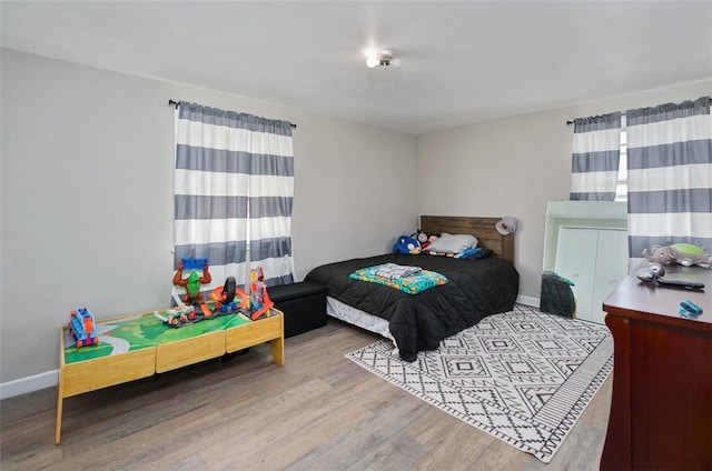 bedroom featuring wood finished floors and baseboards