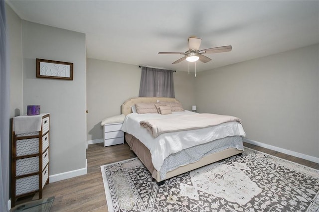 bedroom featuring wood finished floors, baseboards, and a ceiling fan