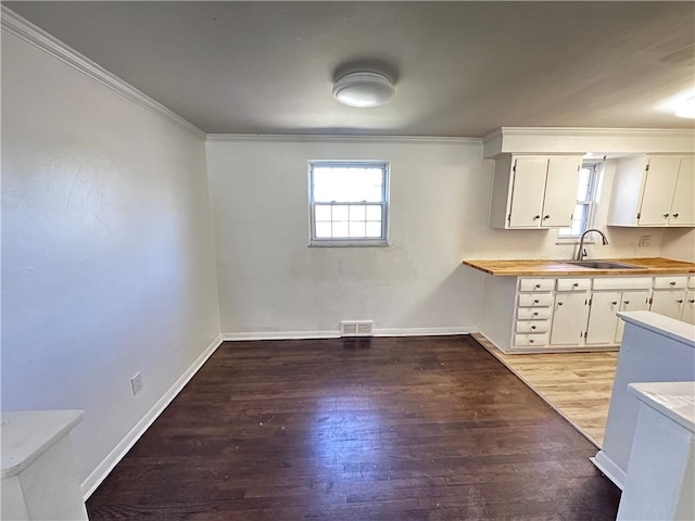 419 Elias Dr, Penn Hills, PA 15235 - kitchen with a sink, crown molding, light wood-type flooring, baseboards, and white cabinets