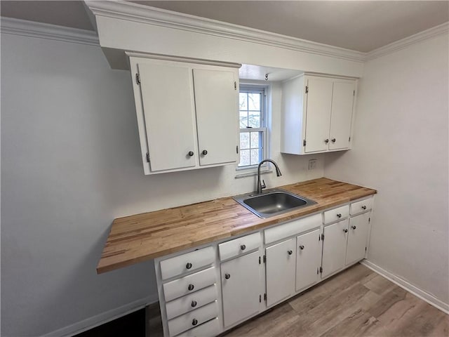 419 Elias Dr, Penn Hills, PA 15235 - kitchen featuring a sink, white cabinetry, light wood-type flooring, wooden counters, and ornamental molding