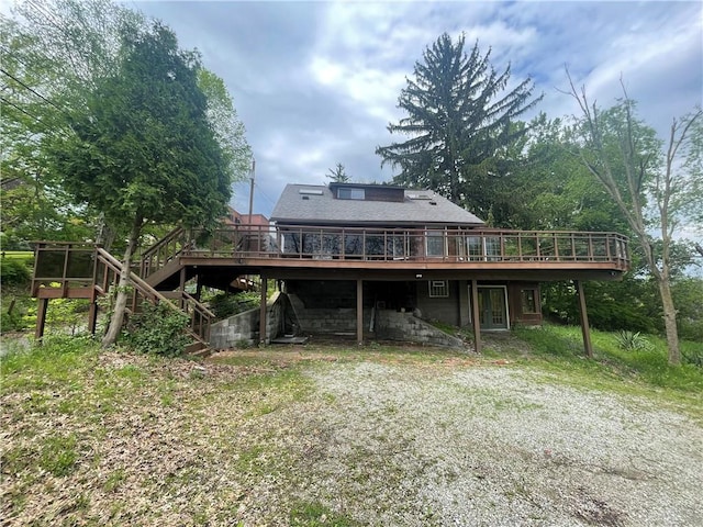 back of property featuring a wooden deck and stairs
