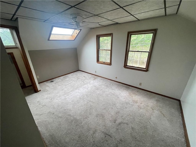 additional living space featuring vaulted ceiling, carpet, plenty of natural light, and baseboards