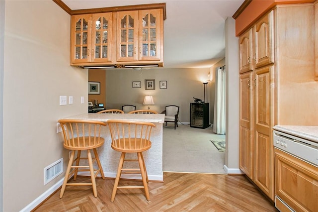 707 Cherry Blossom Ct, Murrysville, PA 15626 - kitchen with a breakfast bar, glass insert cabinets, light countertops, and baseboards