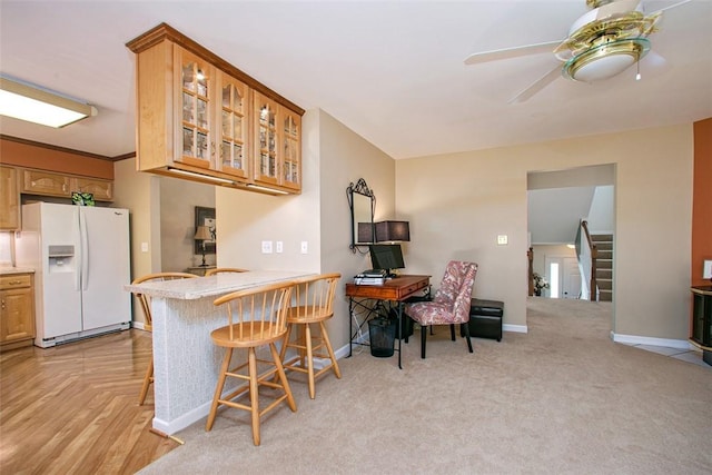 707 Cherry Blossom Ct, Murrysville, PA 15626 - kitchen with white refrigerator with ice dispenser, ceiling fan, glass insert cabinets, baseboards, and a kitchen bar