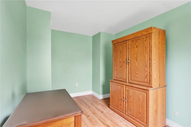 empty room featuring light wood finished floors and baseboards